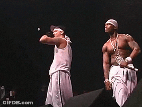 Two Men Singing Into Microphones On A Stage GIF