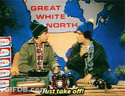 Two Men Sit At A Table With A Sign That Says Great White North GIF