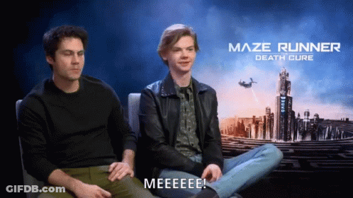 Two Men Sit In Front Of A Maze Runner Death Cure Poster GIF