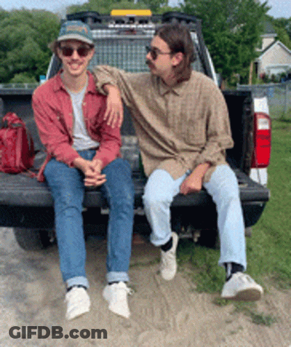 Two Men Sit On Back Of Truck GIF