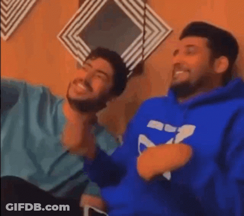 Two Men Sitting And Laughing One In Blue Hoodie GIF