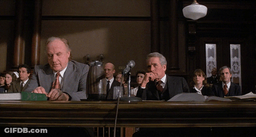 Two Men At Courtroom Table With Objection Text GIF