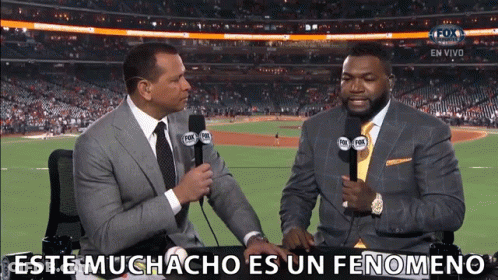 Two Men Sitting At A Table With Microphones And The Words Este Muchacho Es Un Fenomeno Written On The Bottom GIF