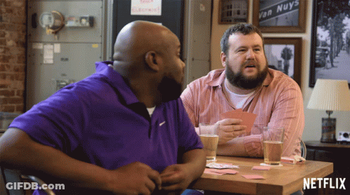 Two Men Sitting At Table With Netflix Logo GIF