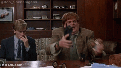 Two Men Sitting At A Table With One Saying Oh My God We 'Re Burning Alive While The Other Holds A Gun GIF