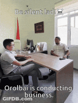 Two Men Sitting At Desk With Skull And Crossbones GIF