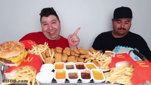 Two Men Sitting At Table Full Of McDonald's Food GIF