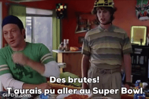 Two Men Sitting At Table One Wearing Helmet GIF