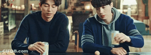 Two Men Sitting At Table With Beer And Eggs GIF