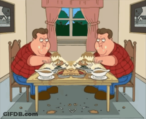 Two Men Sitting At Table With Food GIF