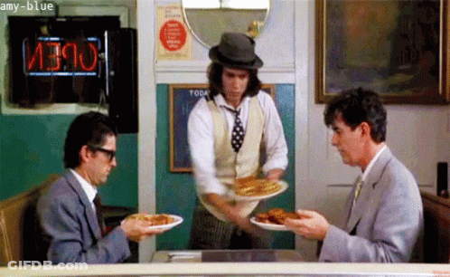 Two Men Sitting At Table With Food GIF
