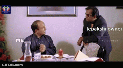Two Men Sitting At Table With Food Lepakshi Owner GIF