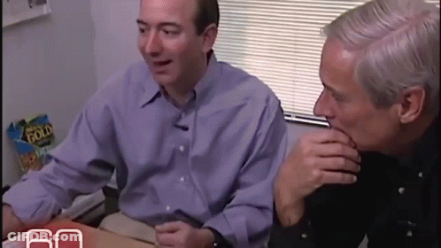 Two Men Sitting At Table With Gold Flake Chips GIF