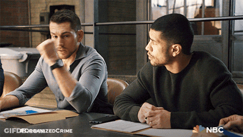 Two Men Sitting At Table With NBC Logo GIF