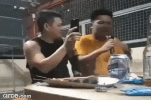 Two Men Sitting At Table With Soda And Food GIF