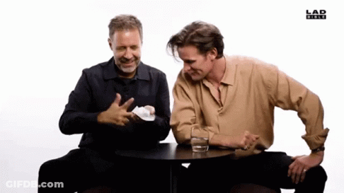 Two Men Sitting At Table With Water And Lad News Logo GIF