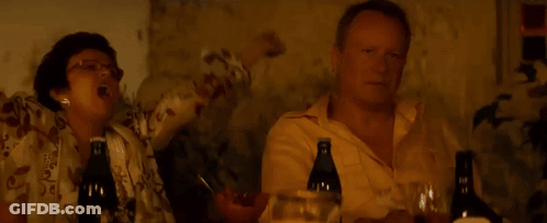 Two Men Sitting At Table With Wine GIF
