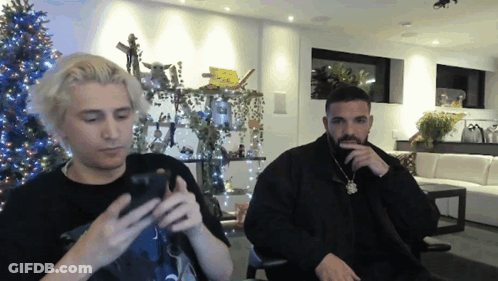 Two Men Sitting By Christmas Tree GIF