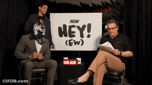 Two Men Sitting By Hey Sign GIF
