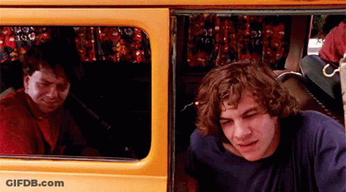 Two Men Sitting In Back Of Yellow Van Looking Out Window GIF