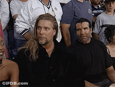 Two Men Sitting In Crowd At Wrestling Event GIF