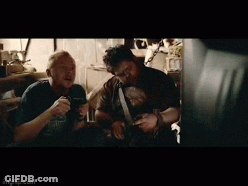 Two Men Sitting In Dark Room Talking GIF