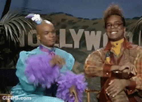 Two Men Sitting In Front Of Hollywood Sign GIF