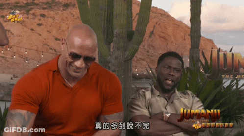 Two Men Sitting In Front Of Jumanji Sign GIF