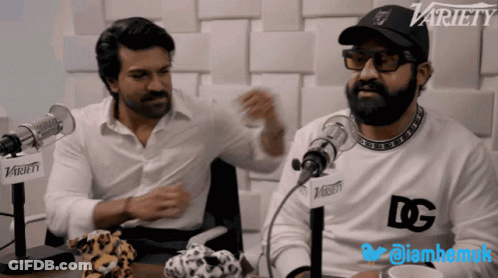 Two Men Sitting In Front Of Microphones GIF