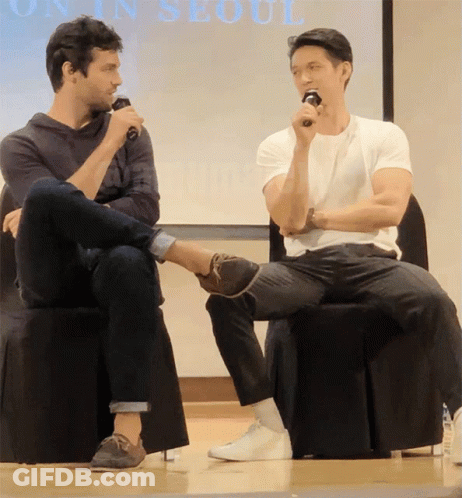 Two Men Sitting In Front Of Seoul Screen GIF