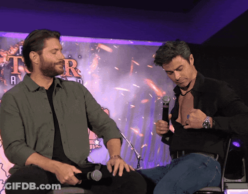 Two Men Sitting In Front Of Tor Sign GIF