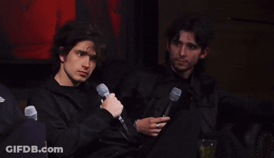 Two Men Sitting Next To Each Other With Microphones GIF