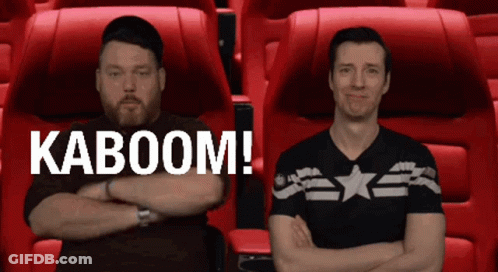 Two Men Sitting Next To Each Other With Their Arms Crossed And The Words Kaboom On The Bottom Right GIF