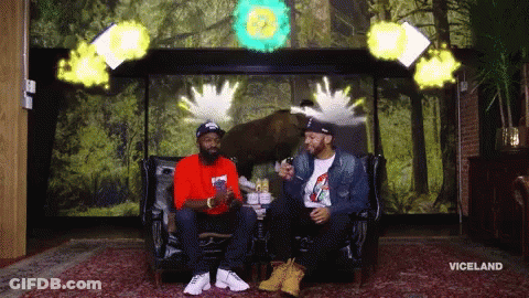 Two Men Sitting On A Couch In Front Of A Wall With The Word Viceland On It GIF