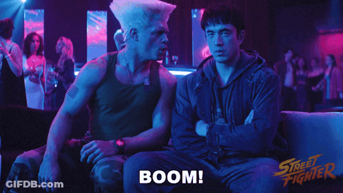 Two Men Sitting On A Couch With The Word Boom Written On The Bottom GIF