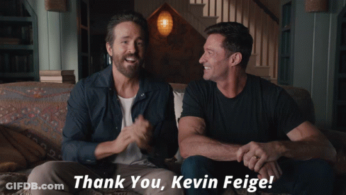 Two Men Sitting On A Couch With The Words Thank You Kevin Feige Written Below Them GIF