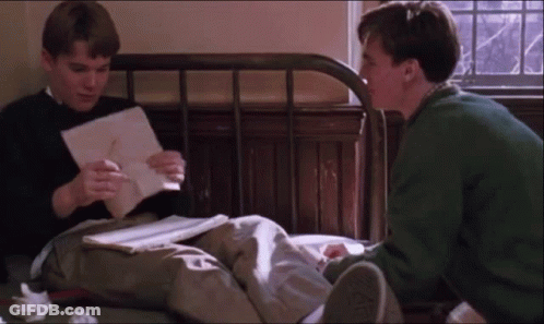 Two Men Sitting On Bed Looking At Papers GIF