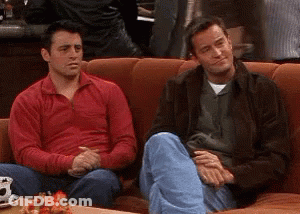 Two Men Sitting On Couch One In Red Sweater GIF