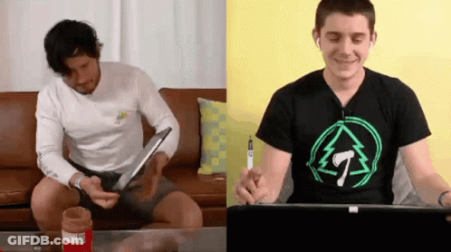 Two Men Sitting On Couch One Wearing T-Shirt GIF