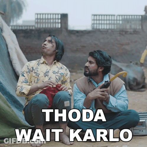 Two Men Sitting On Ground Thoda Wait Karlo GIF