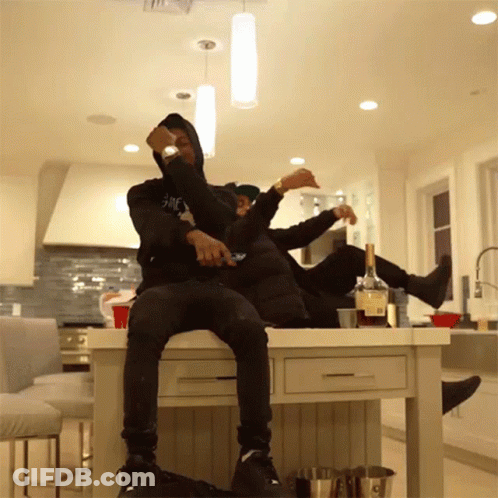 Two Men Sitting On Kitchen Counter GIF