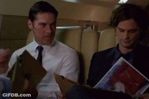 Two Men Sitting On Plane One Holding Clipboard GIF