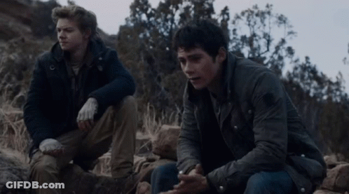 Two Men Sitting On Rocky Hillside Talking GIF