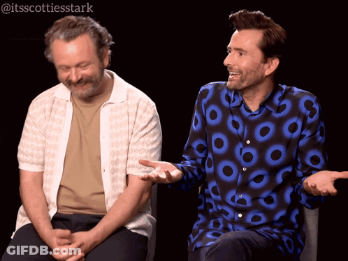 Two Men Sitting One With Circle Shirt GIF