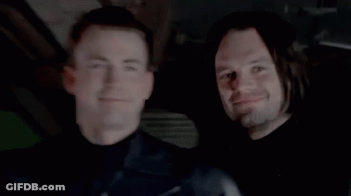 Two Men Smiling In Dark Room GIF