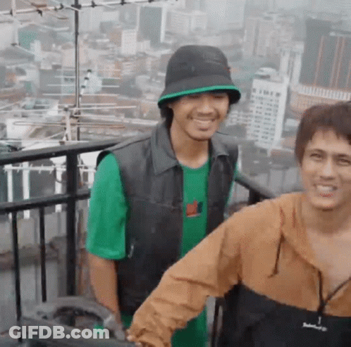 Two Men Smiling On Balcony GIF