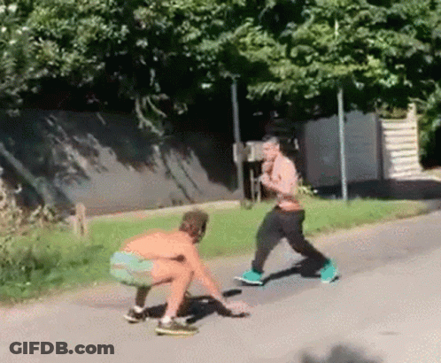 Two Men Squatting Side Of Road GIF