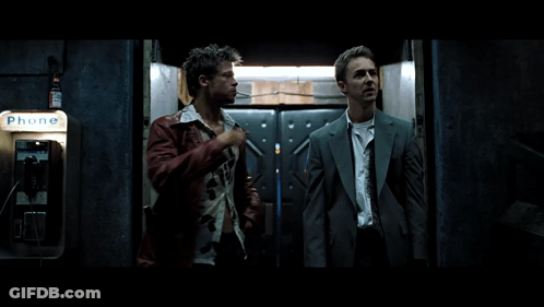 Two Men Stand In Front Of A Phone Booth That Says Phone GIF