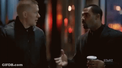 Two Men Standing And Talking In Dark Room GIF