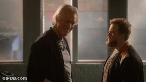 Two Men Standing And Talking In Front Of Window GIF